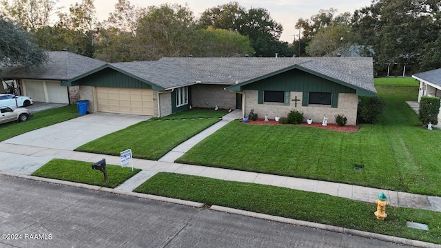 ranch-style house with a garage and a yard