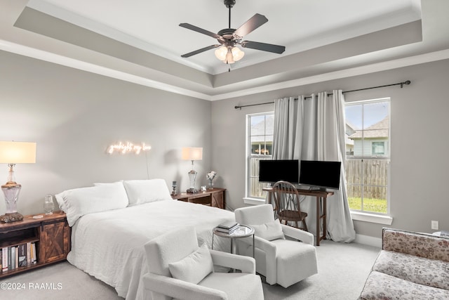 carpeted bedroom featuring ceiling fan and a raised ceiling