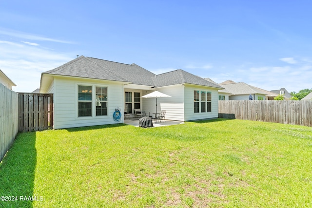 rear view of house featuring a patio area and a yard