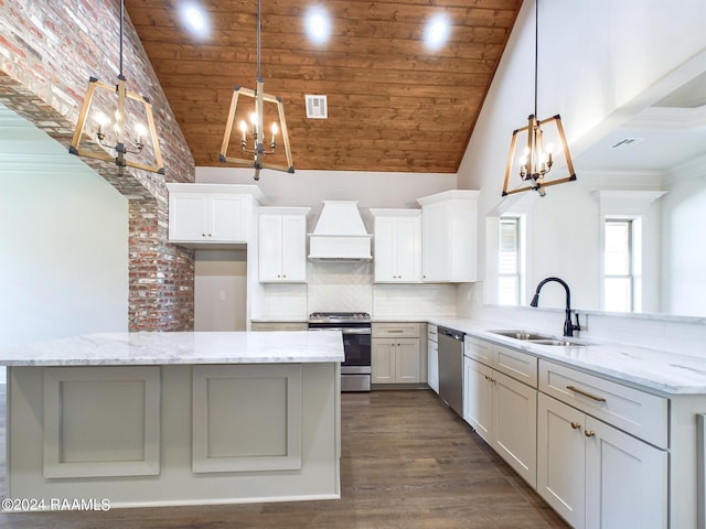 kitchen featuring premium range hood, sink, appliances with stainless steel finishes, a notable chandelier, and kitchen peninsula