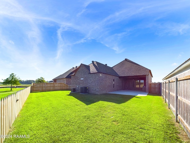 back of property with a yard and central air condition unit