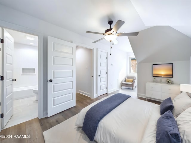 bedroom featuring hardwood / wood-style floors, ceiling fan, lofted ceiling, and ensuite bath