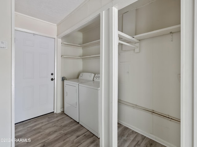 laundry area featuring a textured ceiling, independent washer and dryer, and wood-type flooring