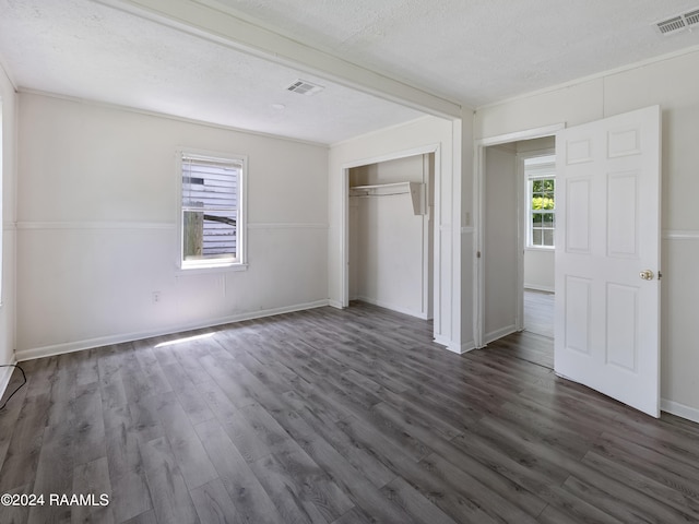 unfurnished bedroom featuring dark hardwood / wood-style flooring, a closet, and a textured ceiling