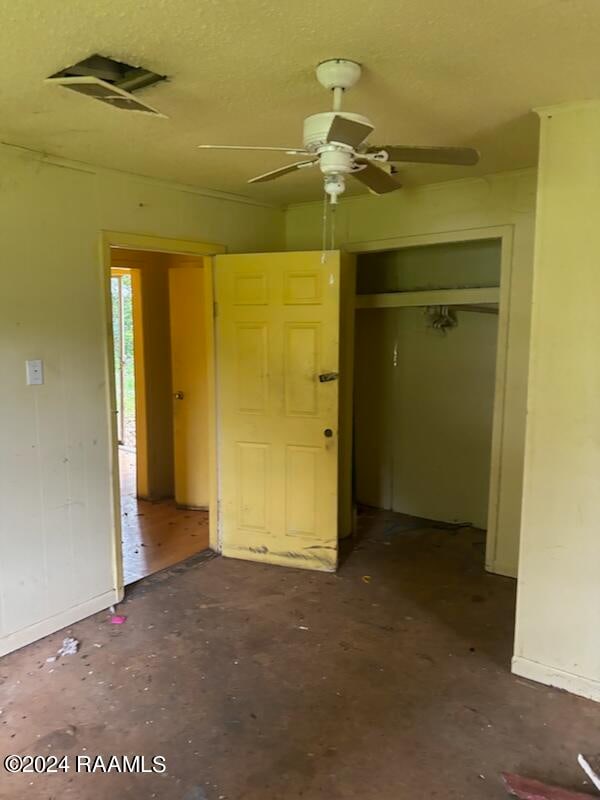 unfurnished bedroom with concrete floors, a closet, and ceiling fan