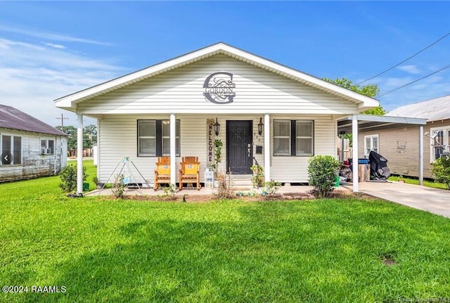 bungalow-style house with a front yard, covered porch, and a carport