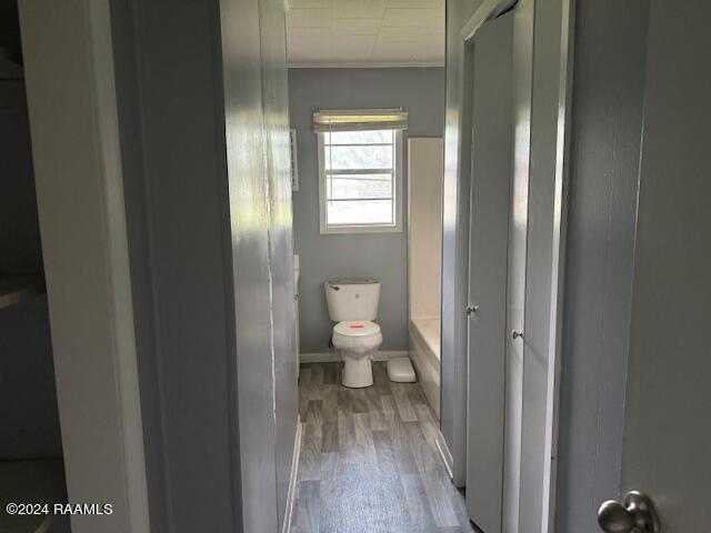 123 Lester St, Ville Platte, LA 70586 - bathroom with toilet, walk in shower, ornamental molding, and hardwood / wood-style flooring