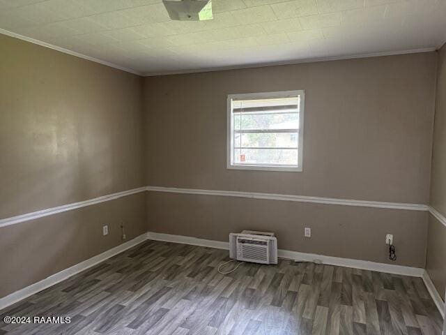 123 Lester St, Ville Platte, LA 70586 - spare room with an AC wall unit, dark hardwood / wood-style flooring, and ornamental molding