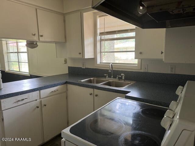 123 Lester St, Ville Platte, LA 70586 - kitchen featuring sink, white cabinetry, and electric range