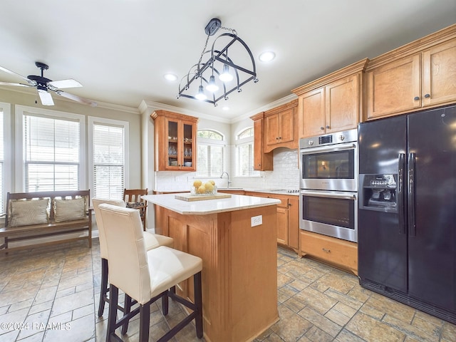 kitchen with appliances with stainless steel finishes, backsplash, crown molding, pendant lighting, and a center island