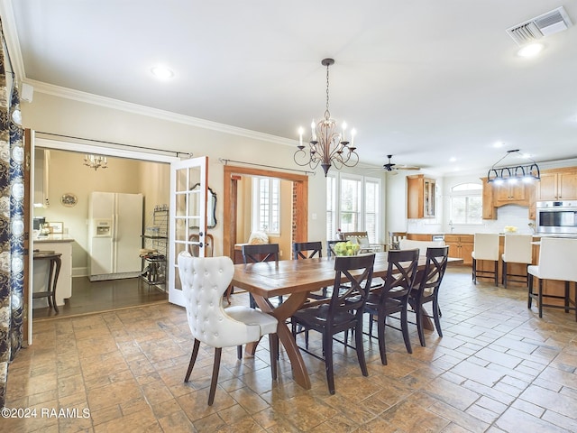 dining space featuring ceiling fan with notable chandelier and ornamental molding