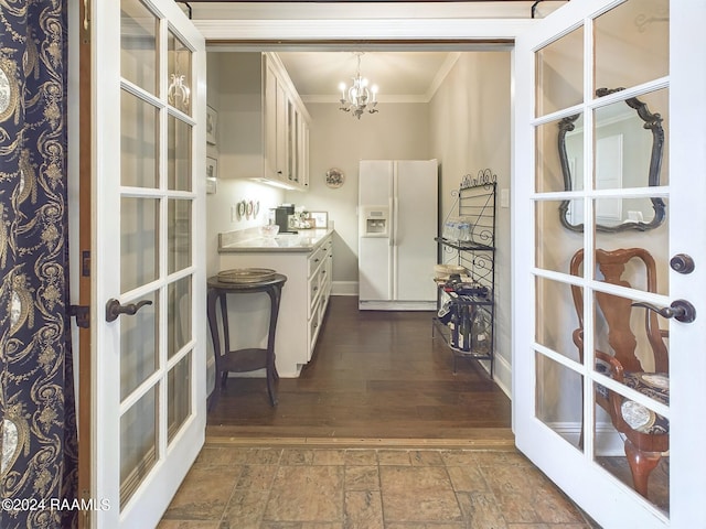 bar with crown molding, pendant lighting, a chandelier, white cabinetry, and white fridge with ice dispenser