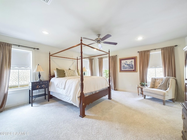 carpeted bedroom featuring multiple windows and ceiling fan