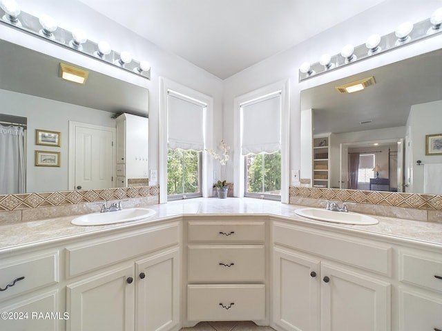 bathroom featuring tile patterned floors, vanity, and decorative backsplash