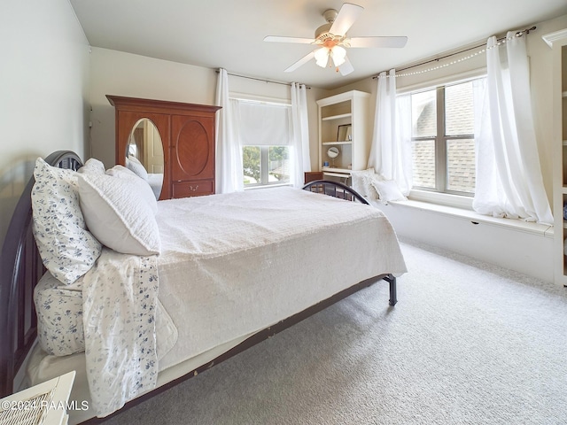 carpeted bedroom featuring ceiling fan and multiple windows