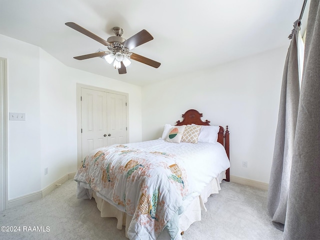 bedroom featuring ceiling fan, a closet, and light carpet