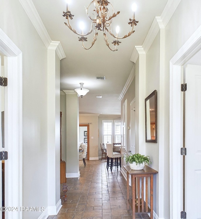 corridor with crown molding and an inviting chandelier