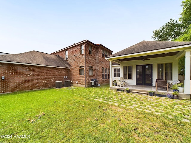 back of house featuring a lawn, ceiling fan, and central AC