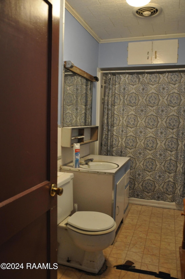 bathroom with vanity, toilet, tile floors, and crown molding