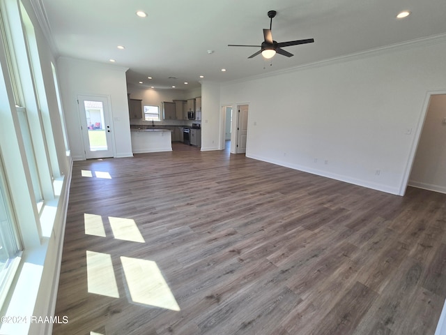 unfurnished living room with dark wood-type flooring, ceiling fan, and crown molding