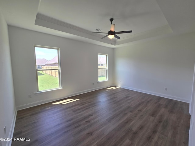 unfurnished room with ornamental molding, a raised ceiling, ceiling fan, and dark hardwood / wood-style floors