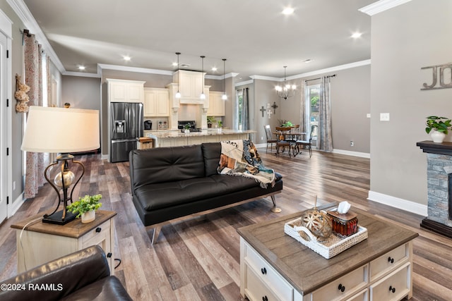 living room featuring a notable chandelier, crown molding, and dark wood-type flooring