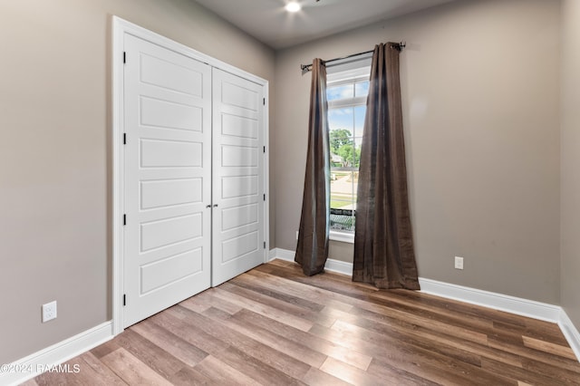 unfurnished bedroom featuring a closet and hardwood / wood-style flooring