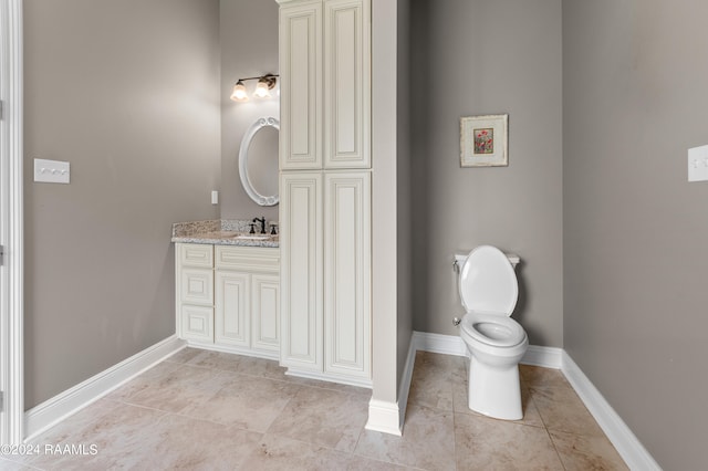 bathroom with tile flooring, vanity, and toilet