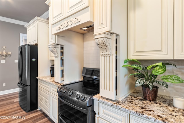 kitchen with light stone countertops, hardwood / wood-style floors, tasteful backsplash, electric stove, and black refrigerator