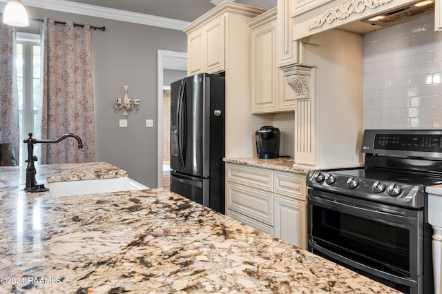 kitchen featuring crown molding, cream cabinets, range with electric cooktop, black fridge, and sink