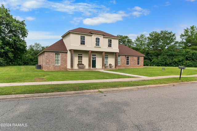 view of front of home with a front yard and central air condition unit