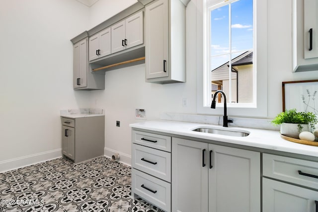 clothes washing area with cabinets, sink, light tile flooring, and electric dryer hookup