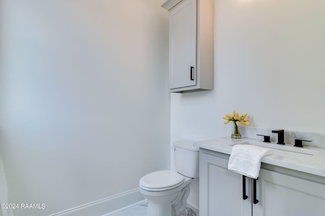 bathroom with tile flooring, vanity, and toilet