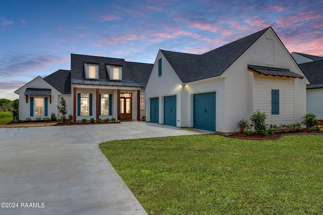 modern farmhouse style home with a garage and a lawn