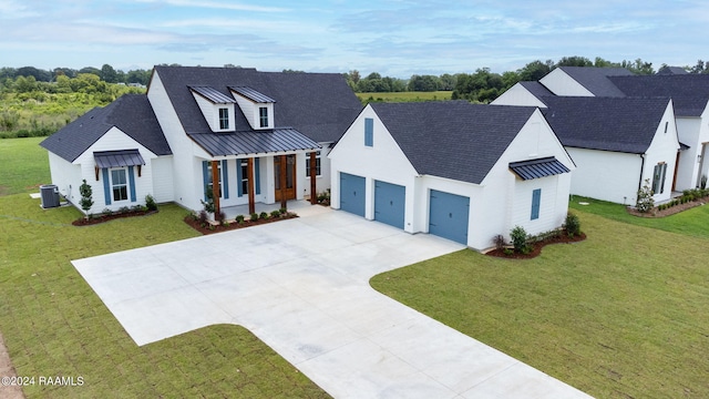 modern inspired farmhouse featuring a garage, a front yard, and central air condition unit