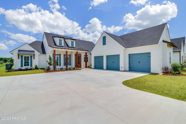 view of front of house featuring a garage, a front yard, and central AC unit