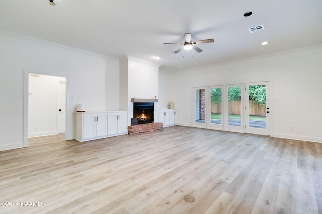 unfurnished living room with a fireplace, light wood-type flooring, ornamental molding, and ceiling fan