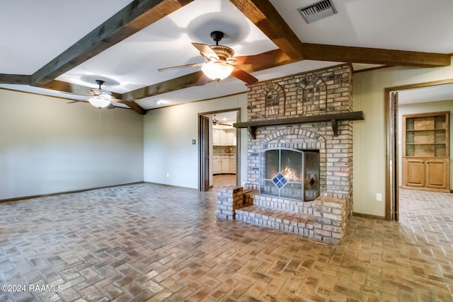 unfurnished living room featuring beamed ceiling, ceiling fan, and a fireplace