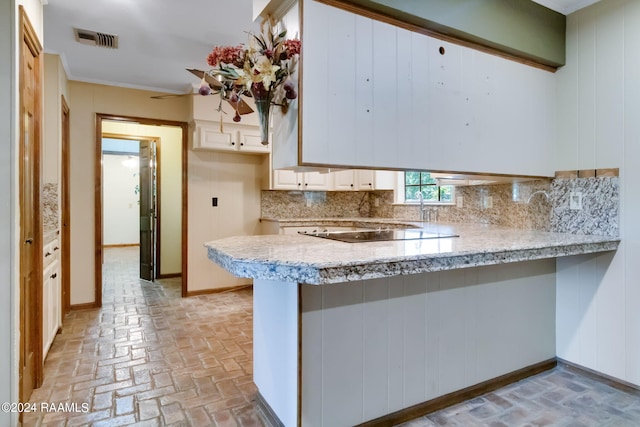 kitchen featuring ceiling fan, kitchen peninsula, and backsplash