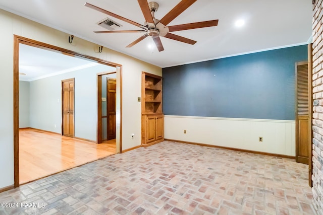 empty room with ceiling fan and crown molding