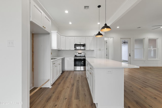 kitchen featuring a center island, dark wood-type flooring, ceiling fan, appliances with stainless steel finishes, and white cabinetry