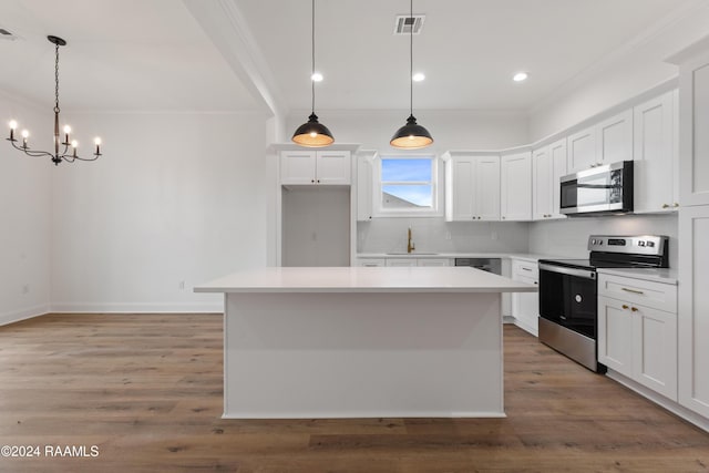 kitchen featuring a center island, white cabinets, appliances with stainless steel finishes, decorative light fixtures, and light hardwood / wood-style floors