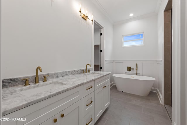 bathroom with tile patterned floors, crown molding, a bathtub, and vanity