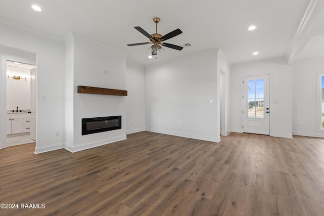 unfurnished living room featuring dark hardwood / wood-style floors, ceiling fan, sink, and crown molding