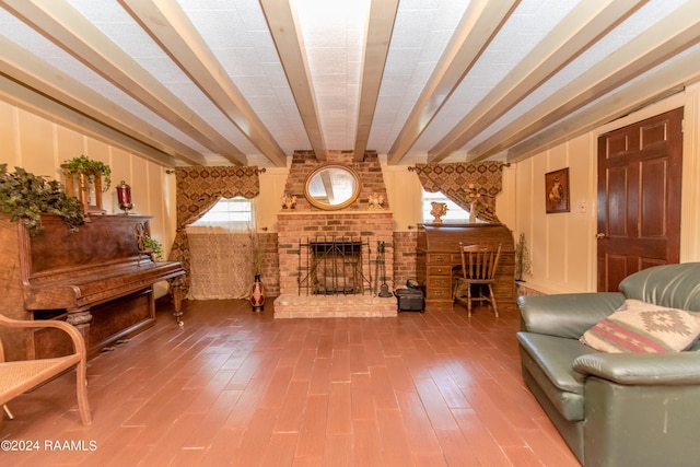 living room featuring beam ceiling, hardwood / wood-style floors, and a brick fireplace