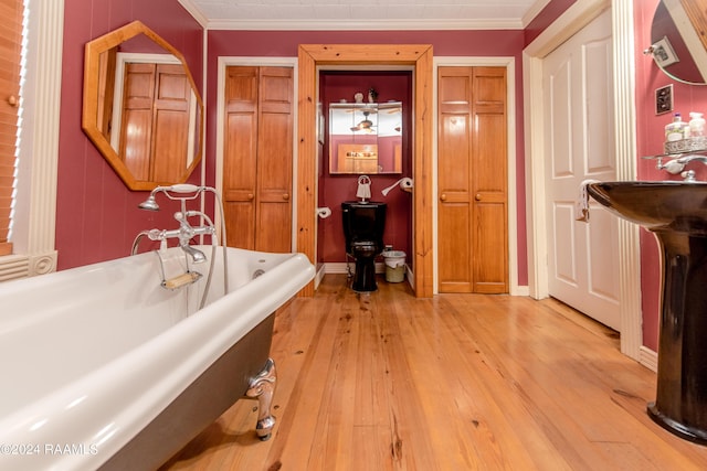 bathroom featuring crown molding, hardwood / wood-style floors, and a bathtub