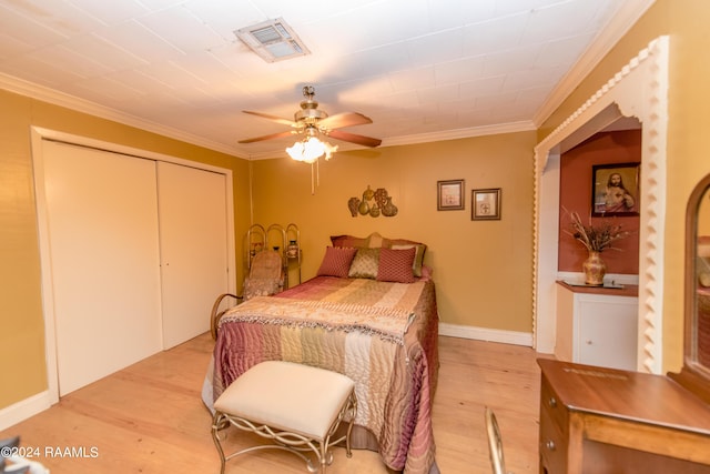 bedroom with ceiling fan, a closet, ornamental molding, and light wood-type flooring