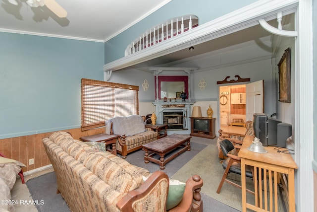 living room with wooden walls, carpet floors, and ornamental molding