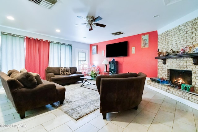 living room with a brick fireplace, tile flooring, and ceiling fan