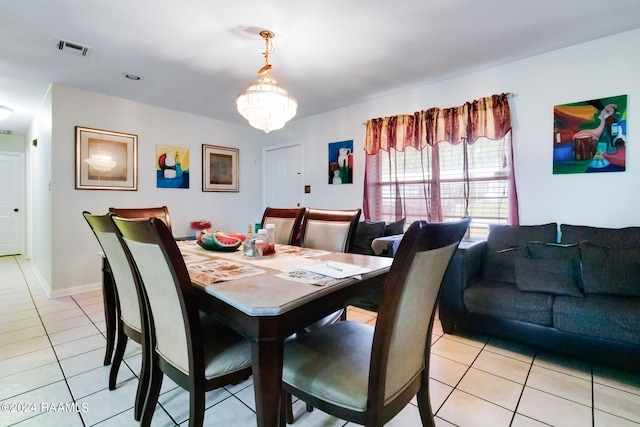 dining area featuring a chandelier and light tile flooring